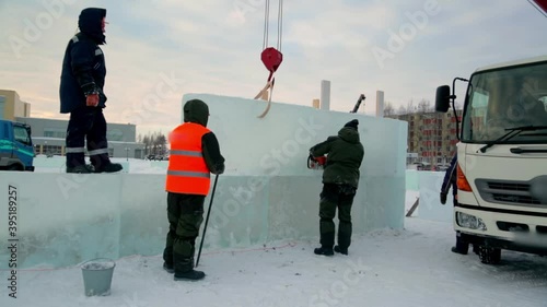 Workers build an ice town from ice blocks for the Christmas holidays