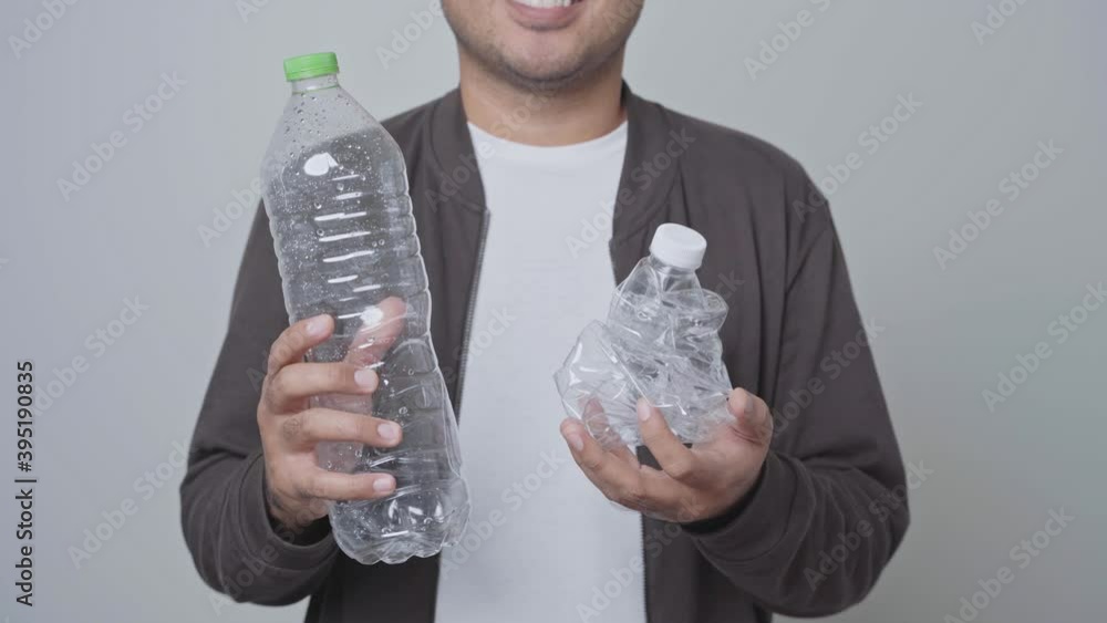 Someone Using Plastic A man showing a used plastic bottle he will be recycled. World ...