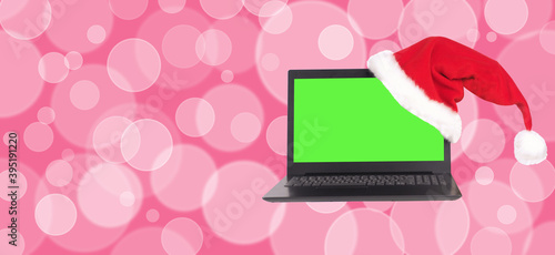 Notebook with Santa hat on colored bokeh background. Pink set.