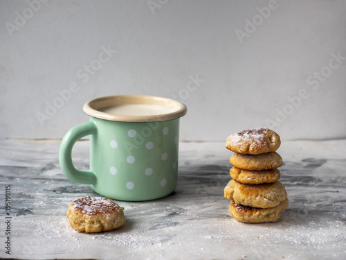 Light lunch with cookies and milk in a turquoise mug with white peas on a black and white background