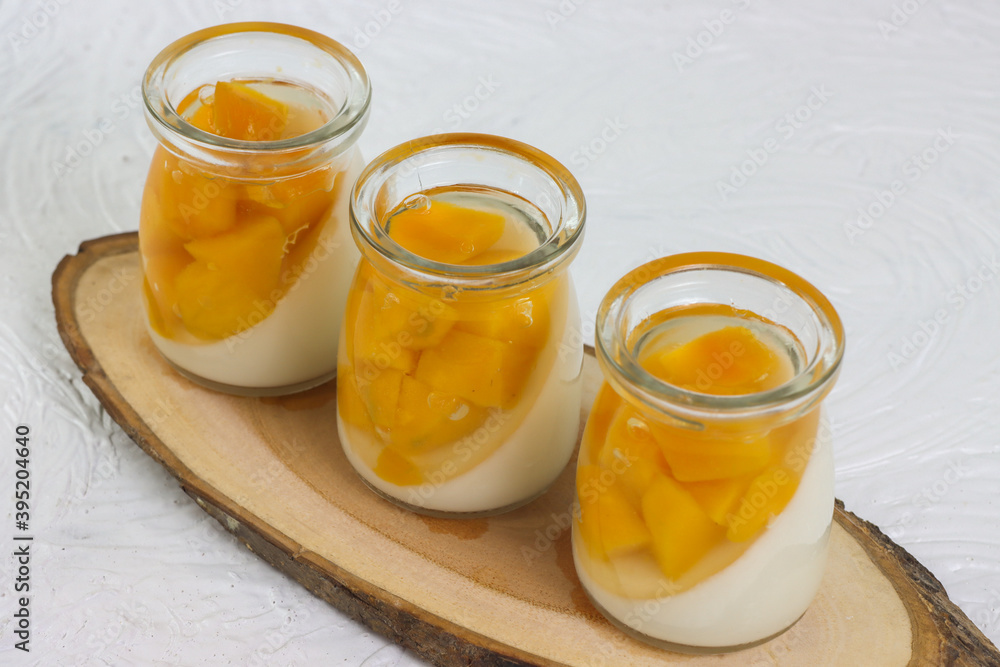 Puding buah mangga. Mango fruit pudding in a glass on a white background.