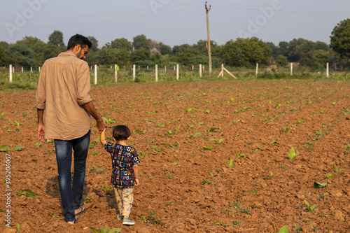 Indian Father and son duo walkig in farm photo