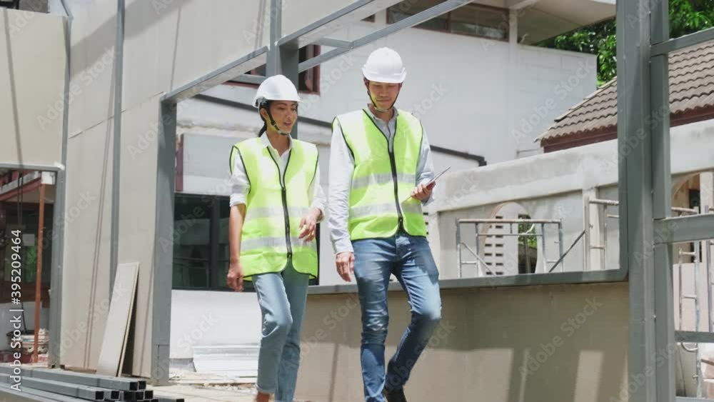 Asian young engineer man and woman walking in construction building. Asian young engineer man and woman walking in construction building.