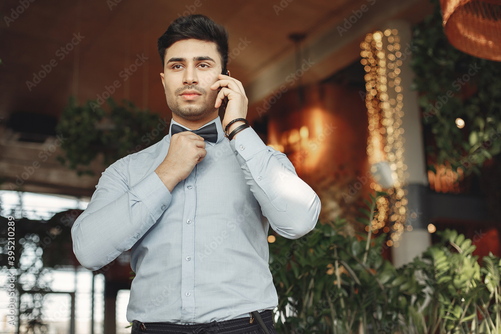 Handsome man in a blue shirt. Businessman working in a office. Guy indoor. Handsome man in a blue shirt. Businessman working in a office. Guy indoor.