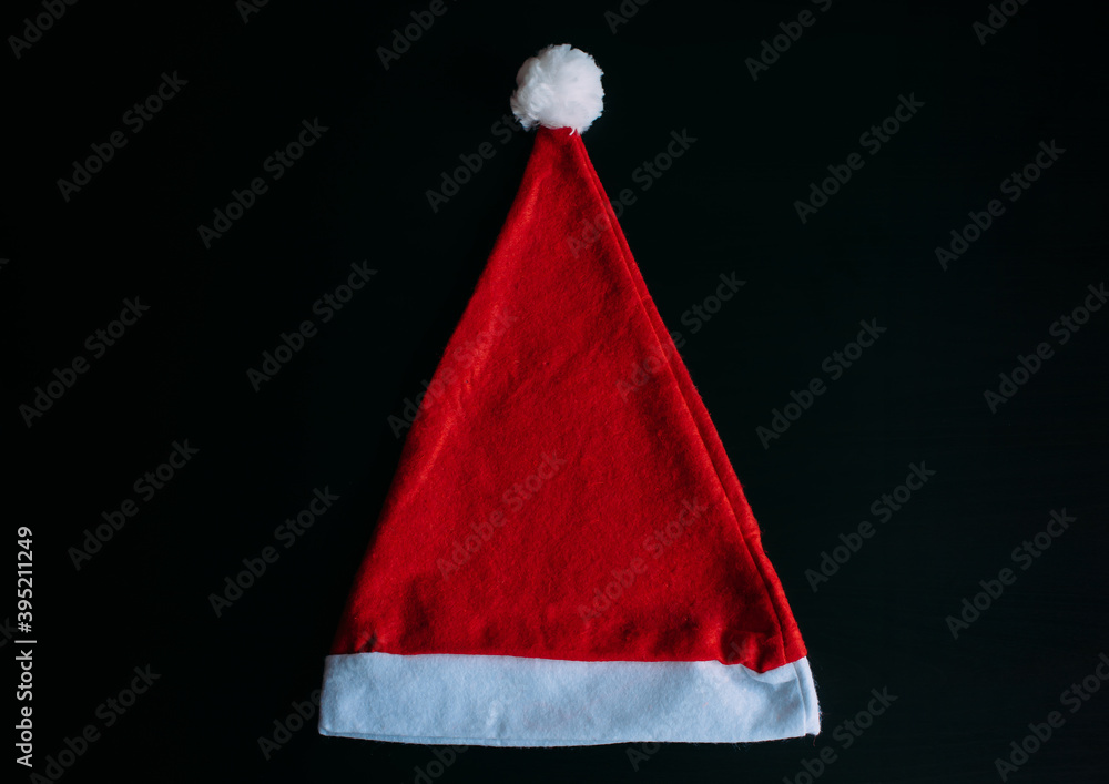 Red Santa Claus hat isolated on black background, top view. Father Christmas cap, close up. New year holidays concept. Red Santa Claus hat isolated on black background, top view. Father Christmas cap, close up. New year holidays concept.