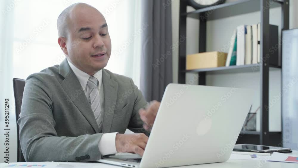 Young Asian businessmen are working on a laptop. He was lethargic and stretched lazily.4K Resolution.
Young Asian businessmen are working on a laptop. He was lethargic and stretched lazily.4K Resolution.