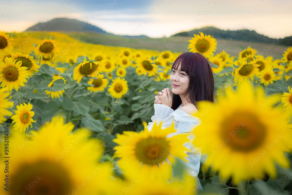 Happy enjoy summer girl in sunflower field in spring. Asian young woman joyful and smiling at sunset time Happy enjoy summer girl in sunflower field in spring. Asian young woman joyful and smiling at sunset time