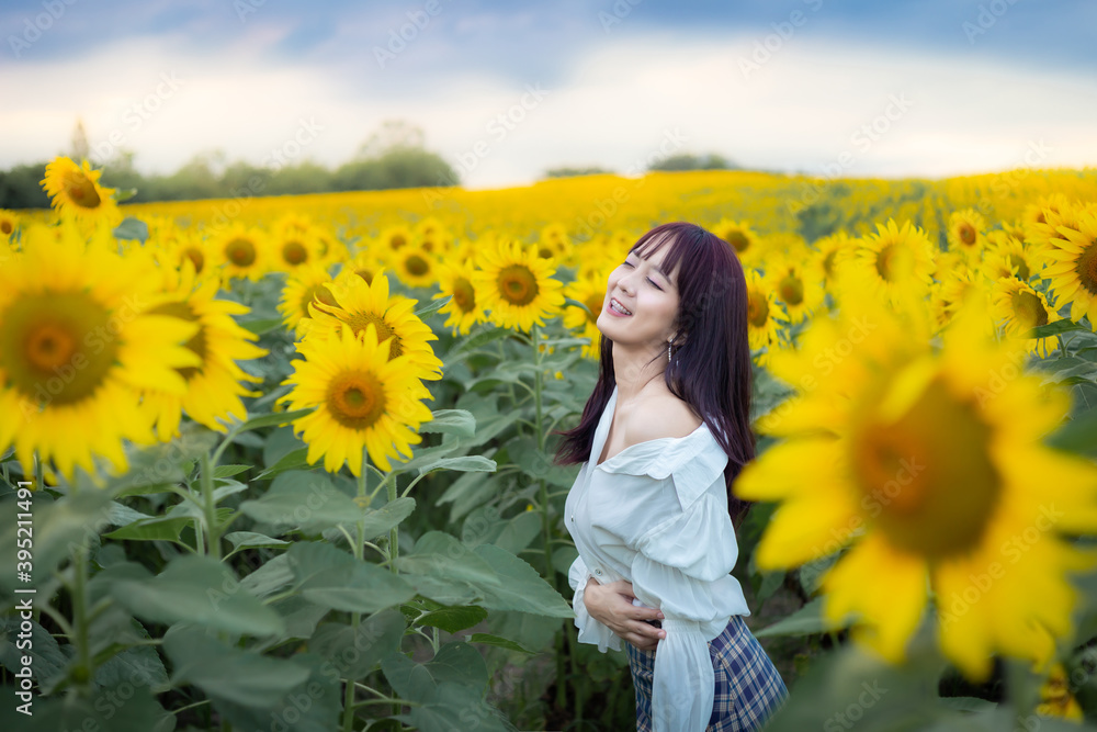 Happy enjoy summer girl in sunflower field in spring. Asian young woman joyful and smiling at sunset time Happy enjoy summer girl in sunflower field in spring. Asian young woman joyful and smiling at sunset time