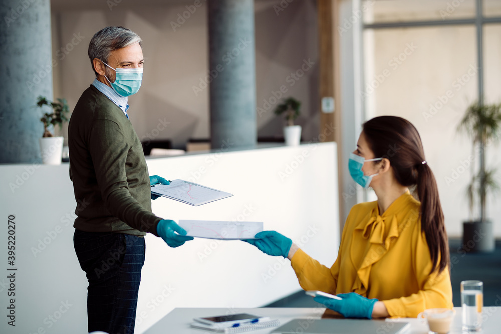 Naklejka premium Business colleagues cooperating while working in the office during coronavirus pandemic.