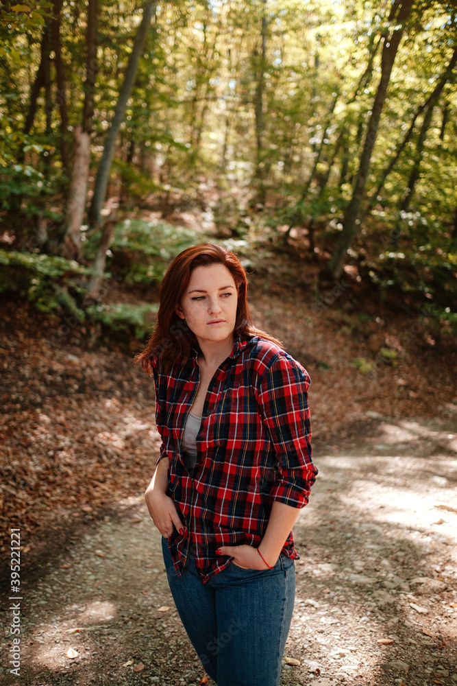 traveler hipster woman standing alone in autumn woods . traveler hipster woman standing alone in autumn woods .
