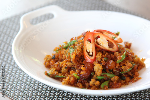 Pad Prik Khing Pla Duk Fu - Crispy fried catfish crumb with spicy and sweet curry paste, kaffir lime leaves and chili sliced. Thai traditional home cuisine
