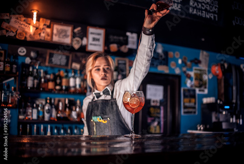 Girl barman concocts a cocktail at the taproom