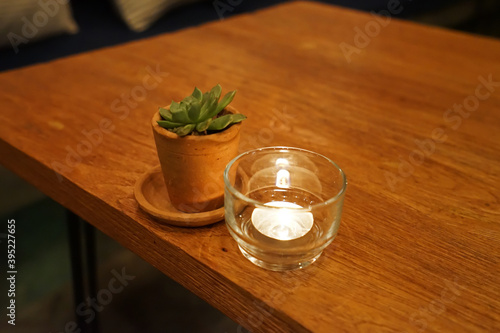Candle and flower clay pot decorated on wooden table