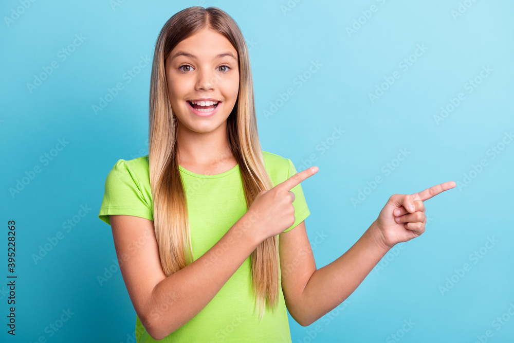 Photo of young happy cheerful good mood positive girl smiling pointing fingers in copyspace isolated on blue color background