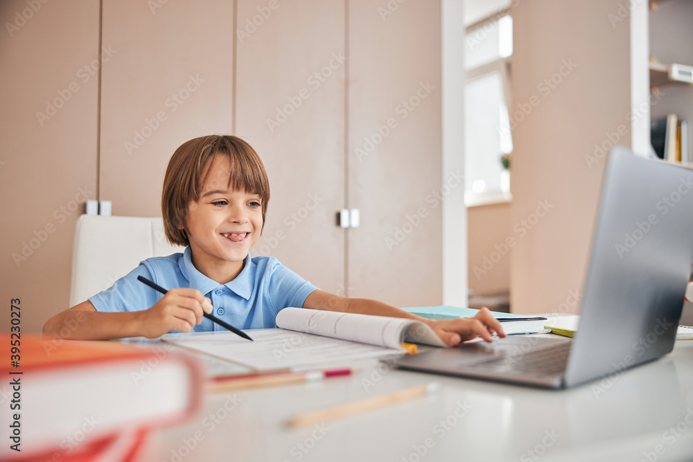 Lovely kid having fun during his online lessons Lovely kid having fun during his online lessons