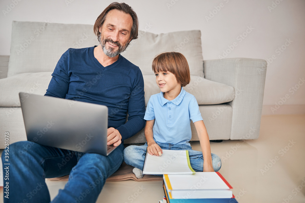 Father and son involved in distant learning during the pandemic Father and son involved in distant learning during the pandemic