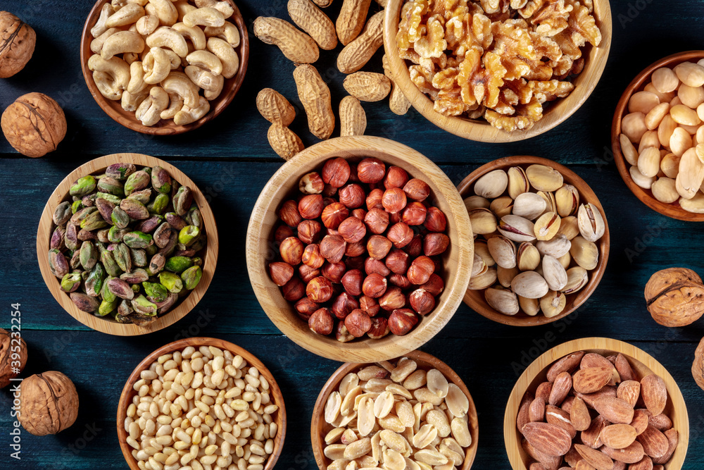 Nuts variety flat lay. Many different nuts, shot from the top on a dark blue background Nuts variety flat lay. Many different nuts, shot from the top on a dark blue background
