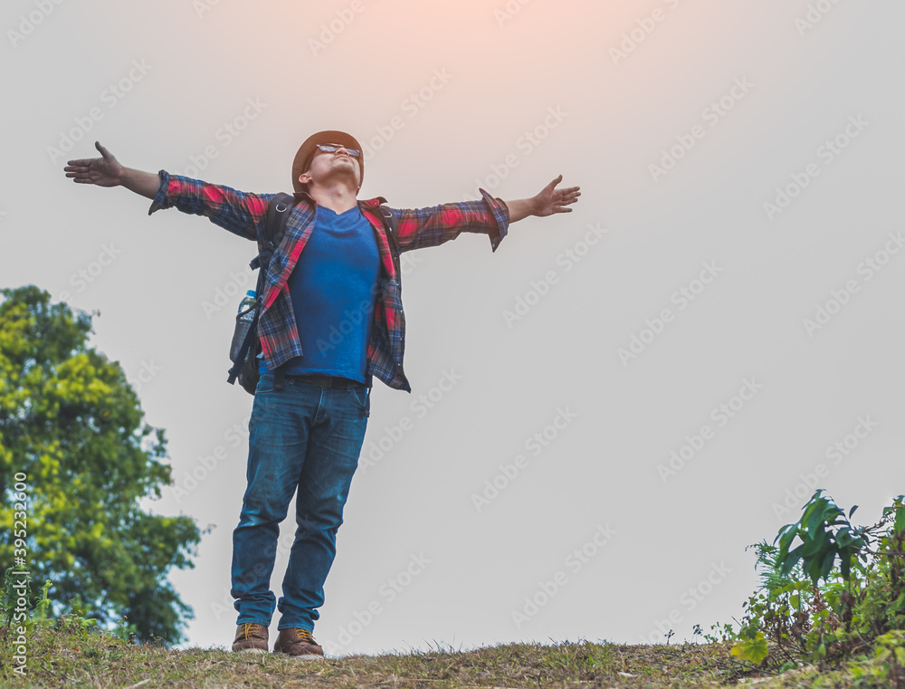 A young man traveler with backpack walking travel in the forest .lift to the sky. A young man traveler with backpack walking travel in the forest .lift to the sky.