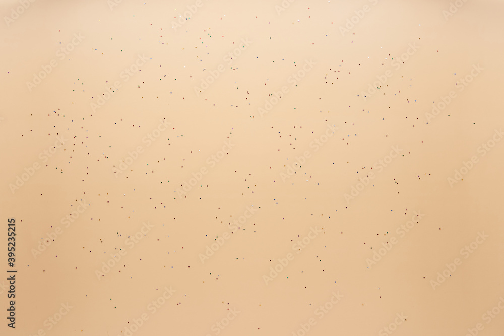 Festive background. Beige background with scattered sparkling colorful confetti. Christmas. Wedding. Birthday. Happy woman's, Mothers, Valentine's Day. Flat lay, top view, copy space.. Festive background. Beige background with scattered sparkling colorful confetti. Christmas. Wedding. Birthday. Happy woman's, Mothers, Valentine's Day. Flat lay, top view, copy space..