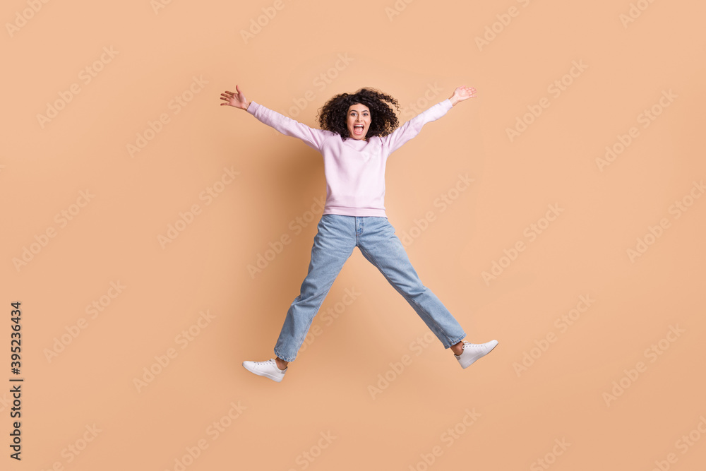 Full body portrait of attractive excited lady jumping raise hands open mouth shout isolated on brown color background Full body portrait of attractive excited lady jumping raise hands open mouth shout isolated on brown color background