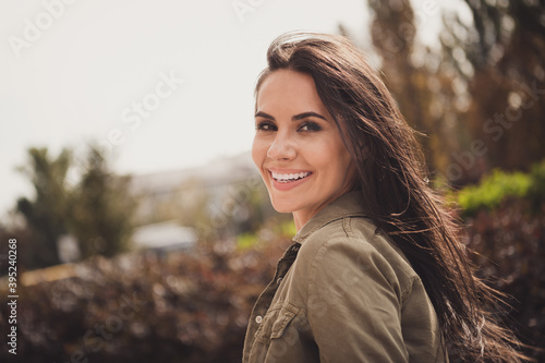 Photo of cheerful funny young woman white toothy smile look camera wear brown shirt park street outside