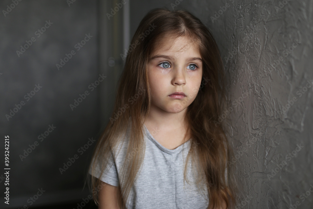 Portrait of cute sad blonde little girl standing by the wall Portrait of cute sad blonde little girl standing by the wall