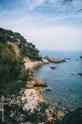 Landscape with views of two pebble coves with some bathers