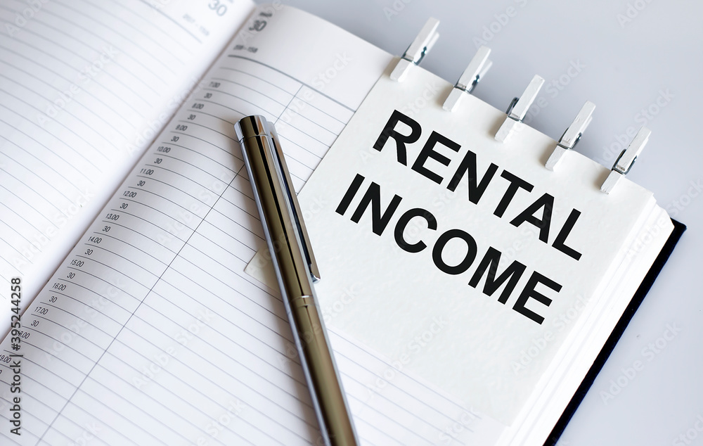 text RENTAL INCOME on the short note texture background with pen text RENTAL INCOME on the short note texture background with pen