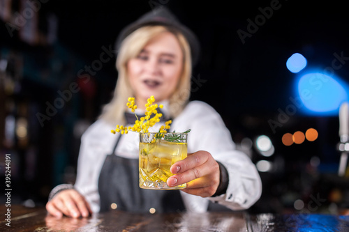 Girl bartender makes a cocktail at the bar photo