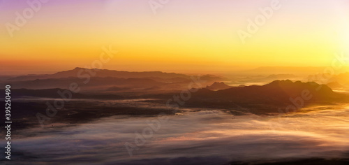 Sunrise on the misty mountains background.