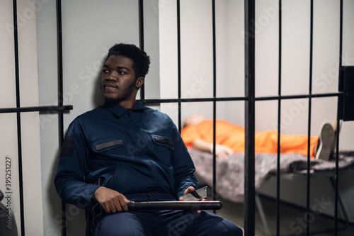 Фотография A prison warden guards cells with prisoners sentenced to life in orange prison u