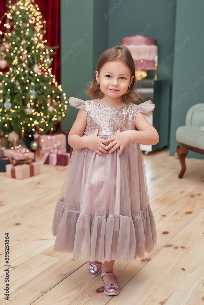 Christmas baby. Child girl with gifts on background of Christmas tree. Xmas greeting card. Merry christmas background. Happy New Year! Winter celebrations, holidays and vacations. Christmas baby. Child girl with gifts on background of Christmas tree. Xmas greeting card. Merry christmas background. Happy New Year! Winter celebrations, holidays and vacations.