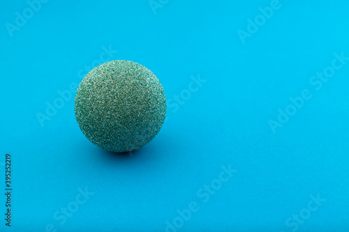Sparkling Christmas ball on blue background, selective focus. Place for text
