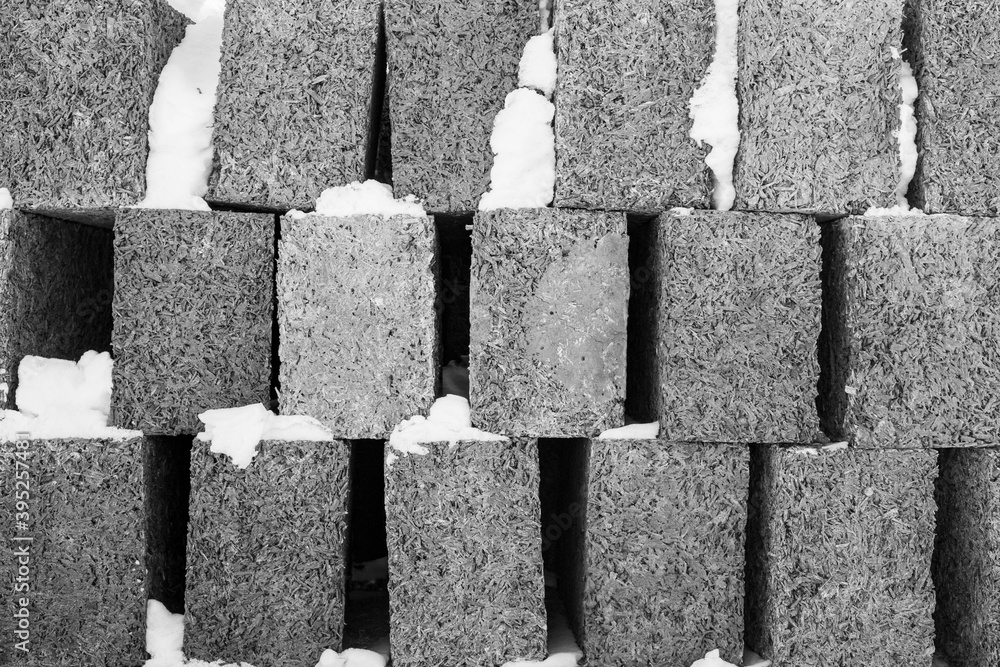 large blocks of arbolite stacked in a stack against a blue sky