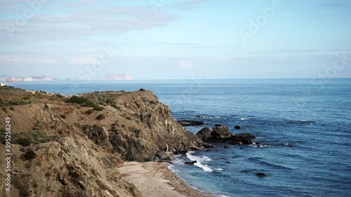 Spanish rocky coastline with cliffs above Cabezo Negro beach, landscape along Almeria coast. Mediterranean region of El Calon, eastern Andalusia in Spain. photo