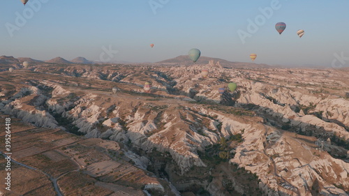 Aerial view from hot air balloon during Sunrise over the fairytale landscape hills of Kapadokya with morning light.