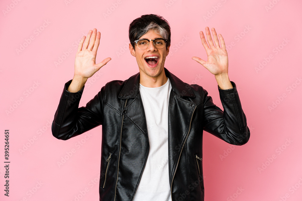 Young skinny hispanic man receiving a pleasant surprise, excited and raising hands. Young skinny hispanic man receiving a pleasant surprise, excited and raising hands.