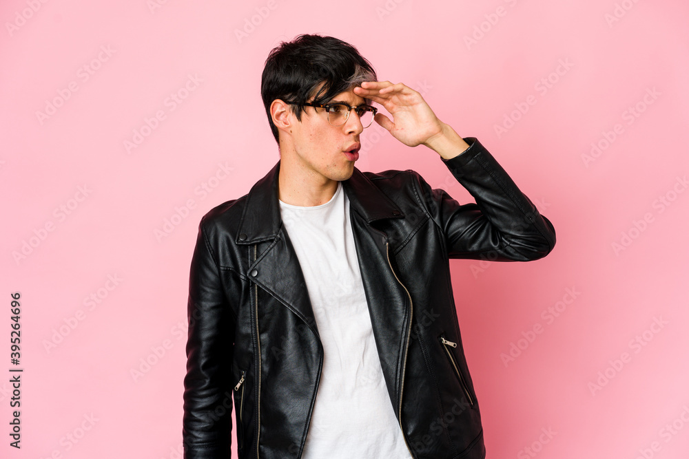 Young skinny hispanic man looking far away keeping hand on forehead. Young skinny hispanic man looking far away keeping hand on forehead.