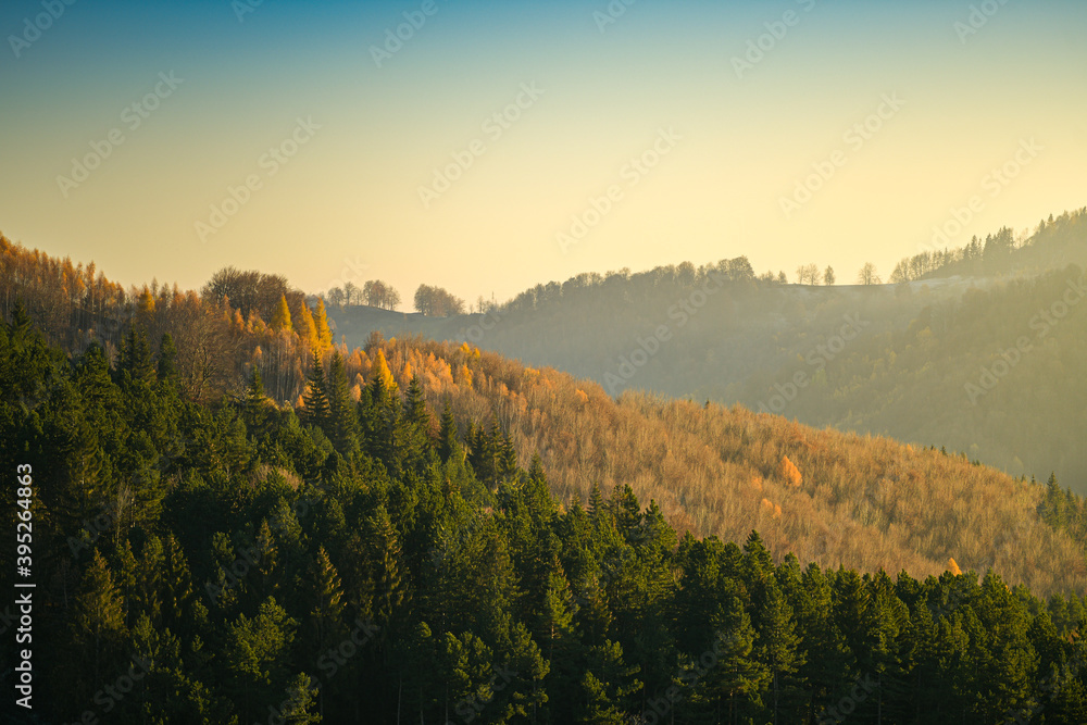 Sunset over the forests and villages from Doftana Valley in Romania at the bottom of Baiului Mountains in autumn landscape after a freezing day