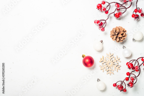 Christmas composition with red decorations at white table.