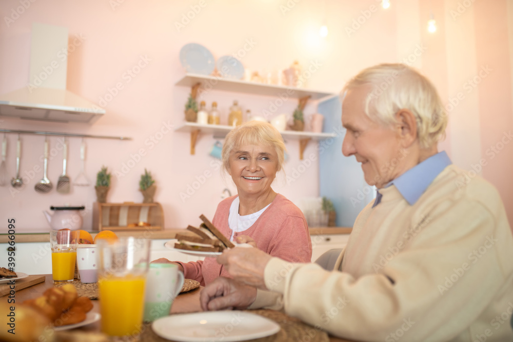 Elderly couple having breafast and looking happy Elderly couple having breafast and looking happy