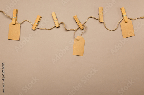 Rope, pins and paper labels on the light brown background.Empty space
