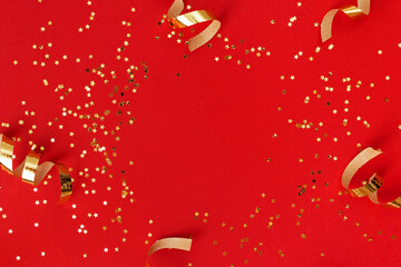 Golden swirls and sparkles on red background.