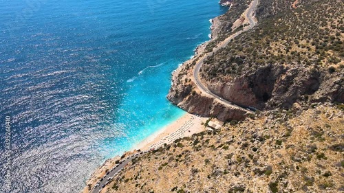 Flying a drone along the coastal strip of a green mountain over a mountain road, driving cars to the beach and the Mediterranean coast photo