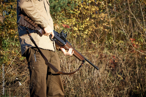 Hunter hunting in the forest with a hunting rifle. A man with a gun.