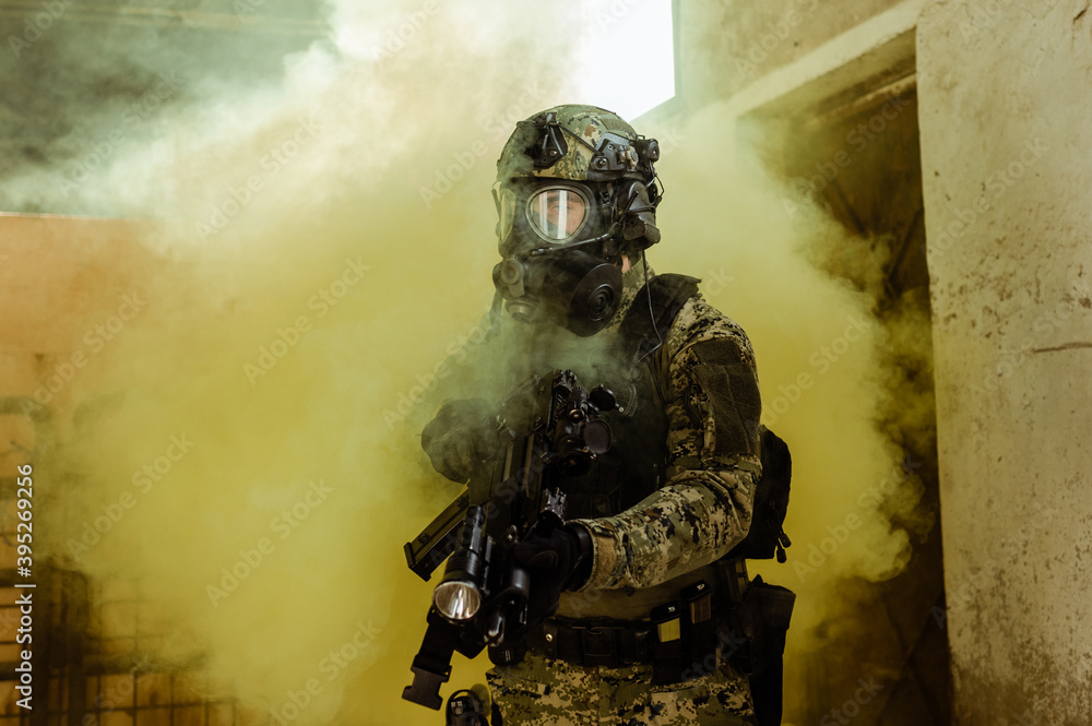 Fototapeta premium Croatian soldier in Cropat woodland uniform wearing gas mask M95 and assault rifle G36.