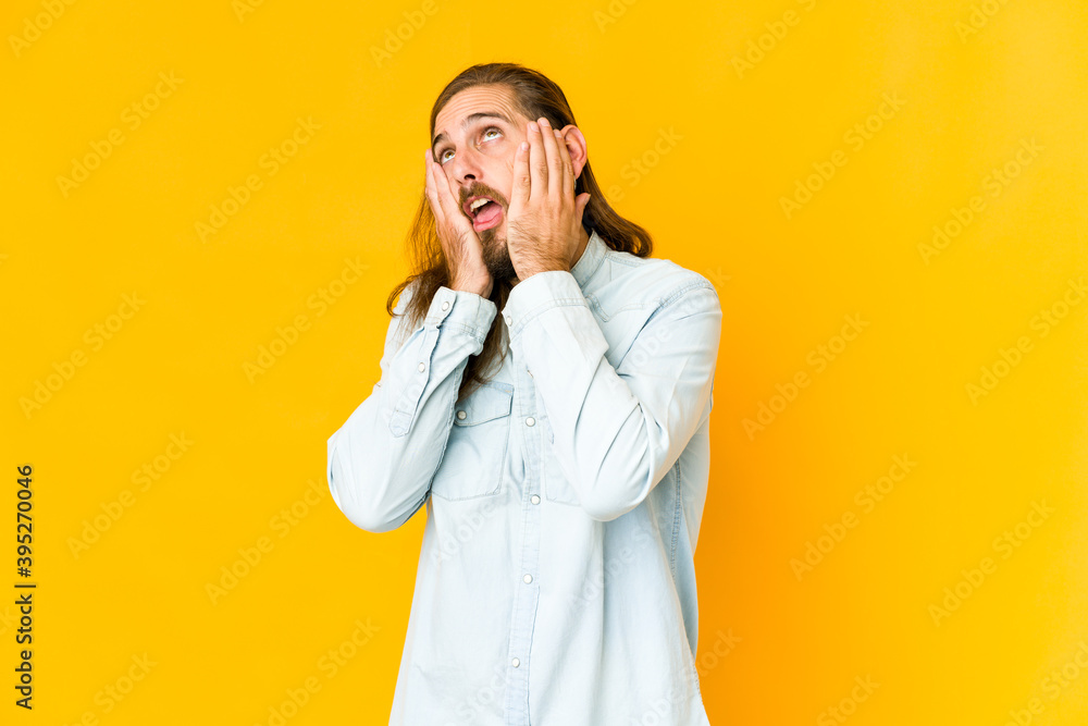 Young man with long hair look whining and crying disconsolately. Young man with long hair look whining and crying disconsolately.
