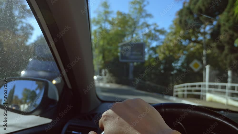 First-person view of a man driving a car moving around the city. sun glare. First-person view of a man driving a car moving around the city. sun glare.