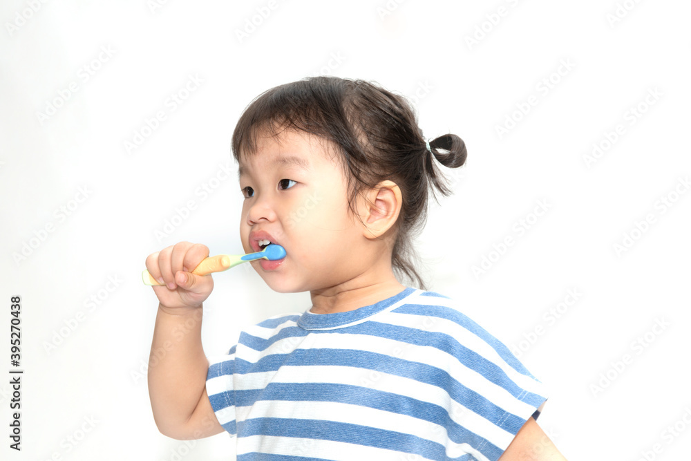 A cute little Asian girl brushing her teeth isolated on white background. Healthy teeth concept. A cute little Asian girl brushing her teeth isolated on white background. Healthy teeth concept.