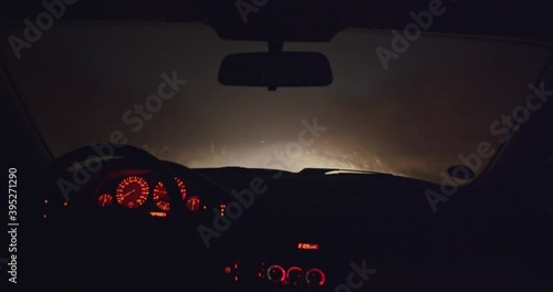Interior of car / driving in a foggy night on a dirt road. Handheld camera shot. Co-Driver showing the way. Cars in the background. photo